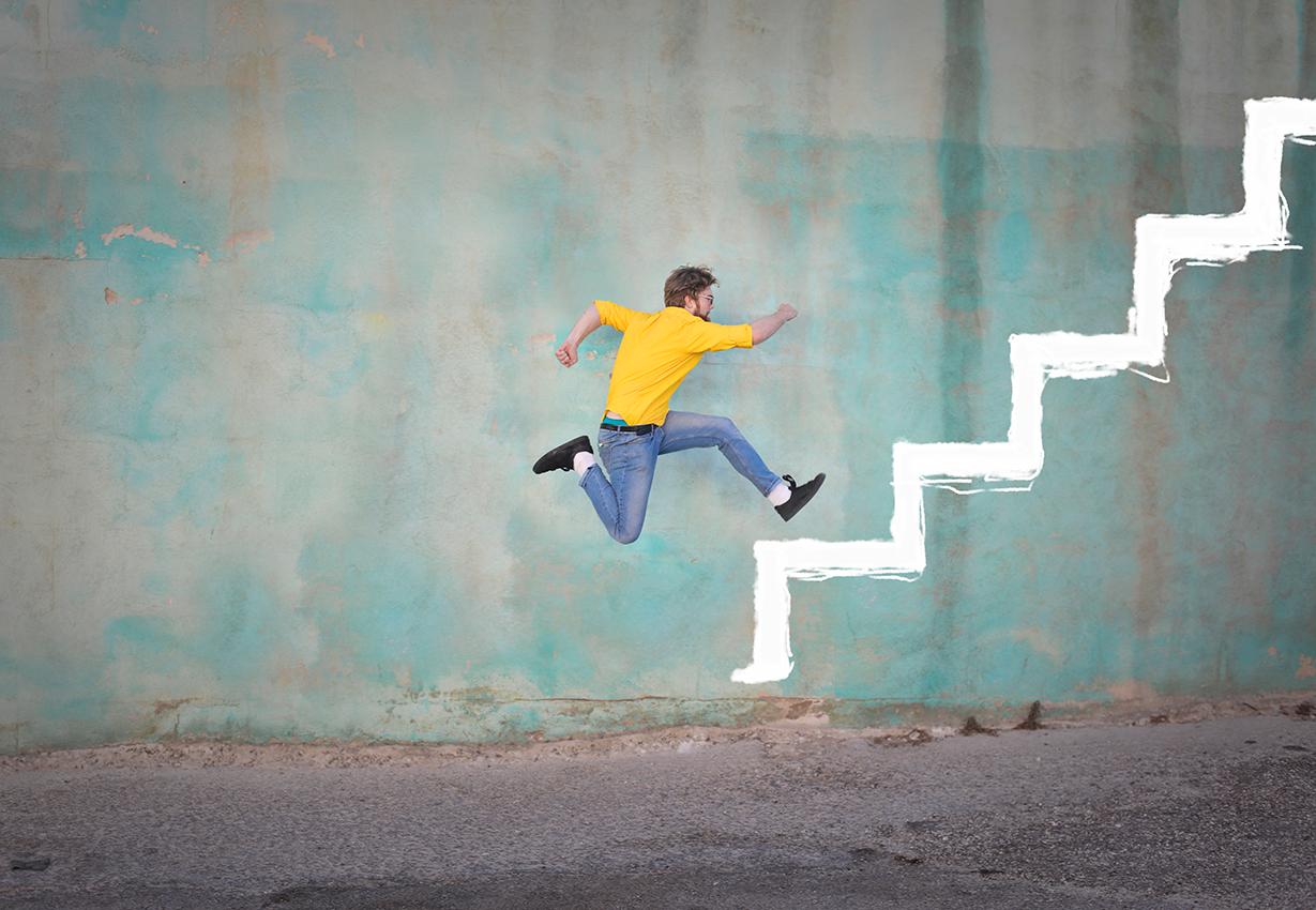 Mies juoksee seinään piirrettyjä portaita pitkin